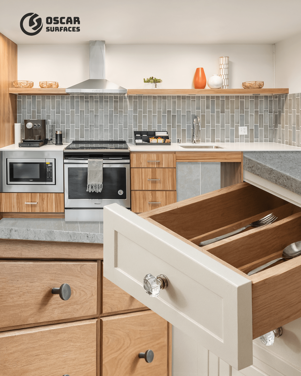 A composite image from Oscar Surfaces of a modern kitchen with grey tile backsplash, with a detailed inset showing an open cabinet drawer with a crystal knob and utensil organizer.